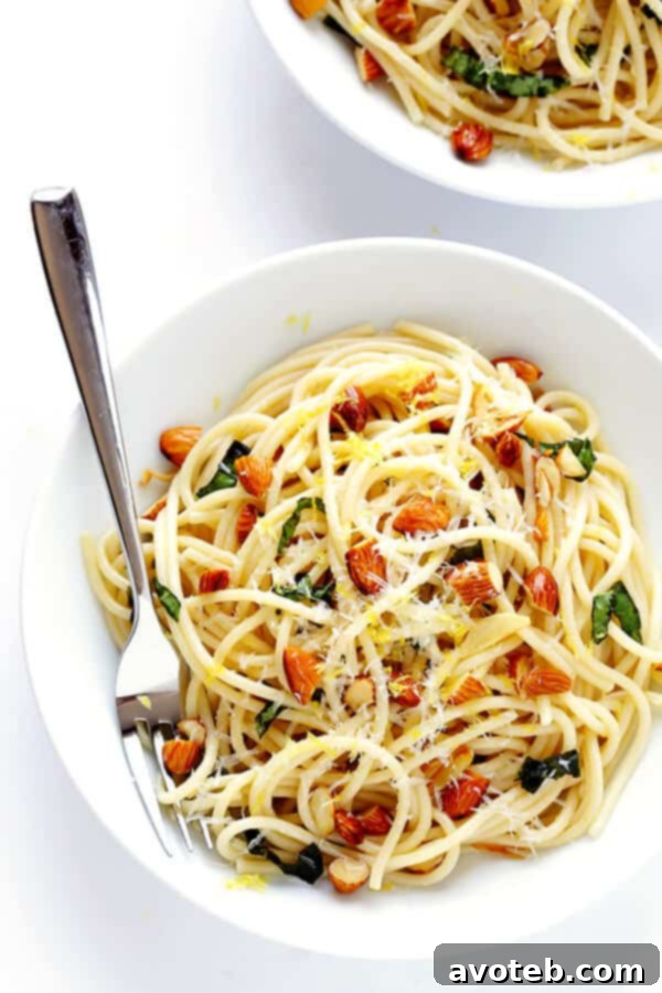 The final dish: A perfectly tossed plate of Lemon Basil Spaghetti with Almonds, garnished with fresh Parmesan and lemon zest, ready to be enjoyed.