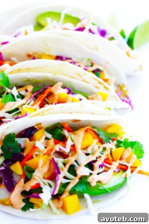 This Mango Chipotle Fish Tacos recipe is made with flaky mild fish, filled with a zesty mango slaw, and drizzled with a creamy chipotle lime sauce. So easy to make, and ready to go in less than 30 minutes! | gimmesomeoven.com