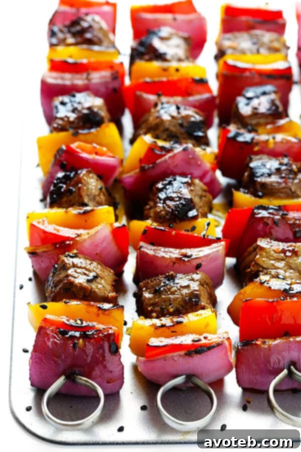 Assembled Korean Steak Kabobs with marinated steak, bell peppers, and red onions, ready for the grill.