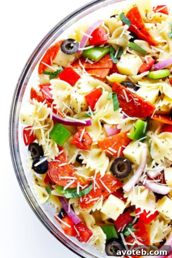 A freshly tossed Pizza Pasta Salad in a white serving bowl, garnished and ready to eat