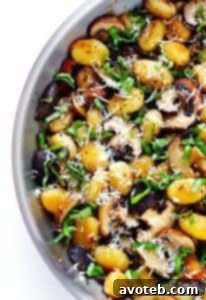 Close-up of a serving of Toasted Gnocchi with Mushrooms, Basil, and Parmesan in a bowl.