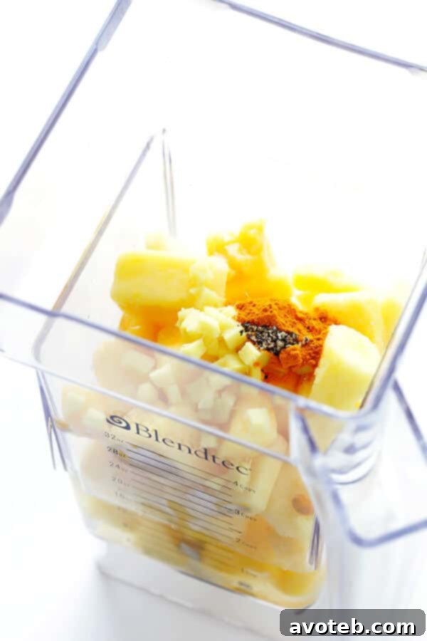 Ingredients for Feel-Good Pineapple Smoothie being blended in a high-speed blender.