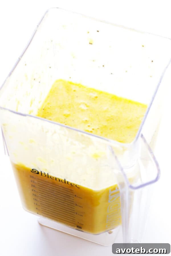 Feel-Good Pineapple Smoothie being blended to a smooth consistency in a blender.