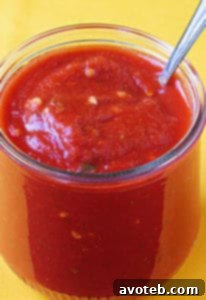 Homemade pizza sauce in a bowl with fresh basil leaves