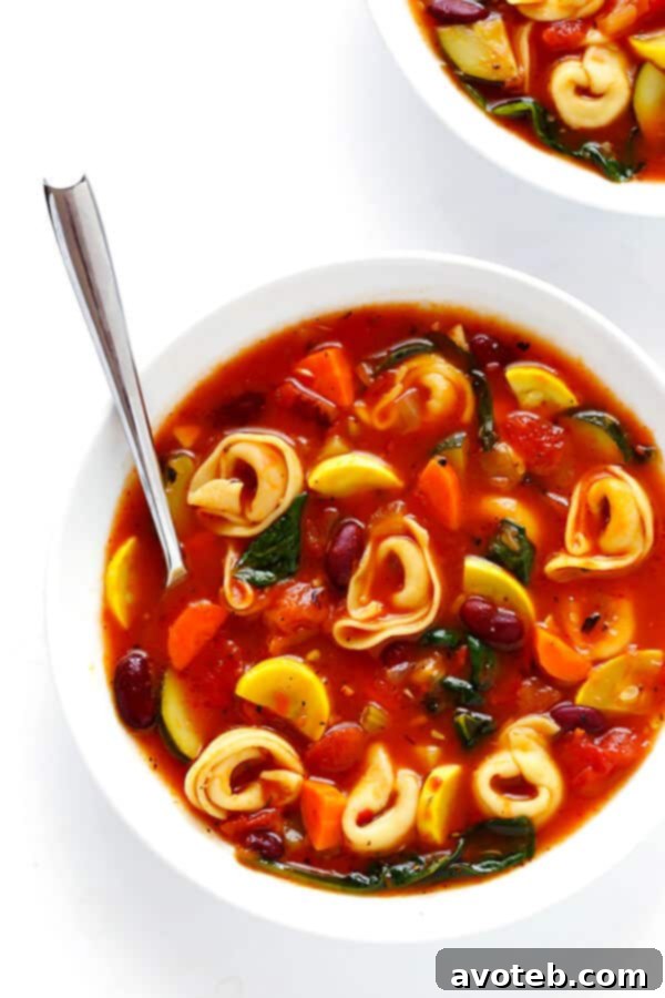 Comforting Tortellini Minestrone 5 The finished Tortellini Minestrone soup, garnished with fresh herbs and ready to be served, highlighting its rich and inviting appearance.