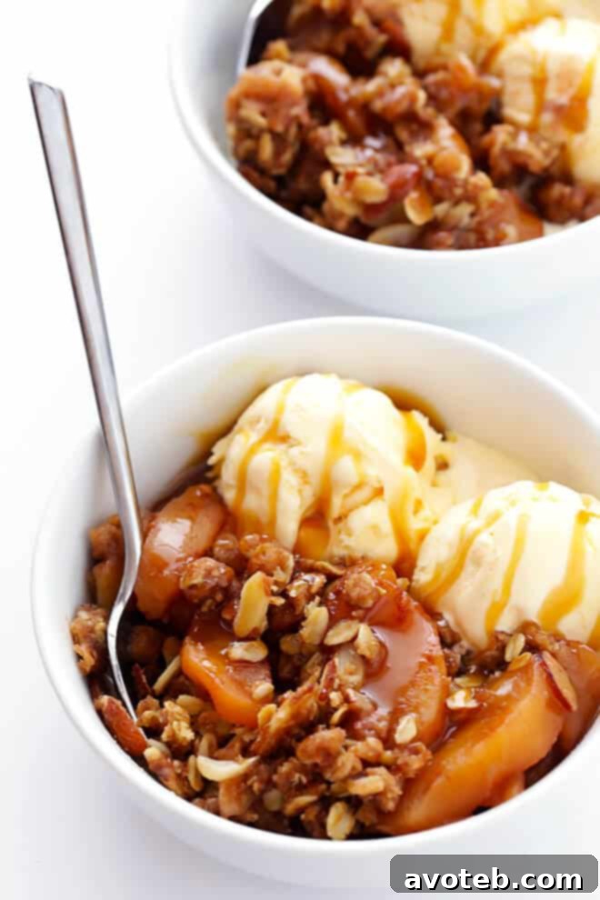Close-up of a serving of Slow Cooker Apple Crisp with vanilla ice cream and caramel sauce.