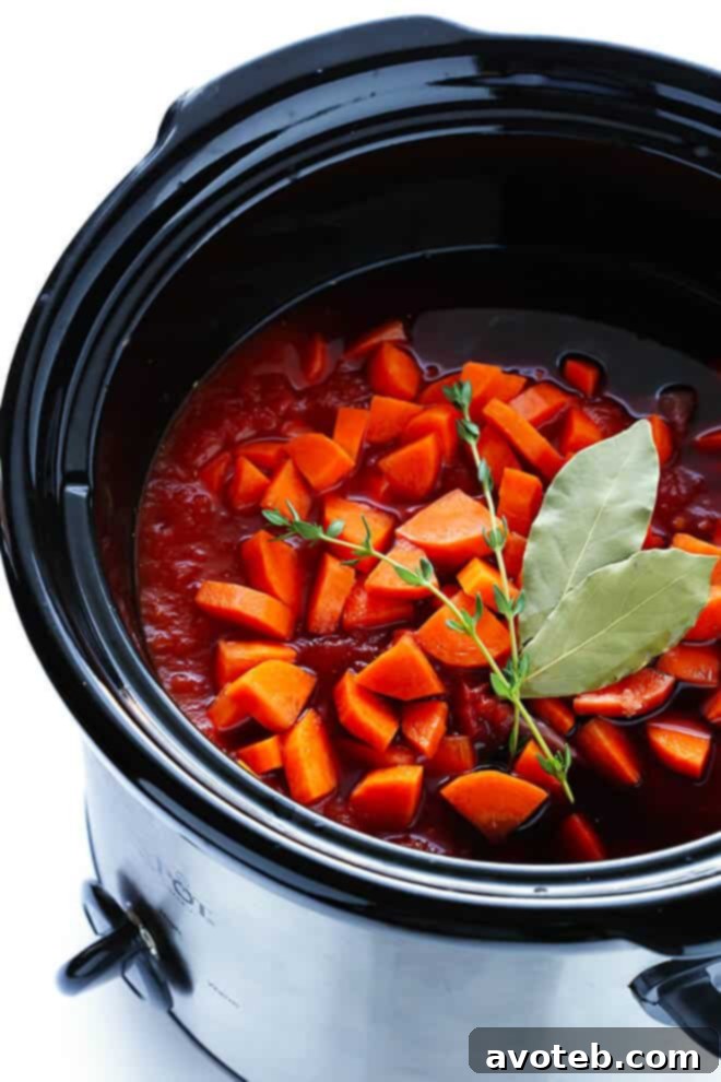 A close-up shot of the rich, slow-simmered beef ragu bubbling in a slow cooker.