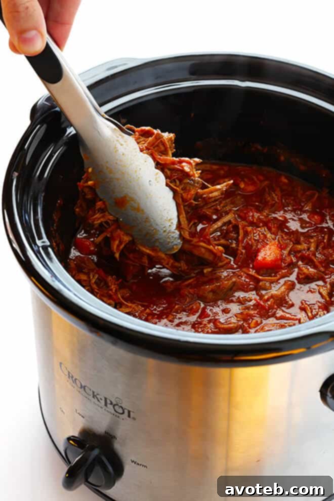 Serving freshly shredded slow cooker beef ragu over a bed of al dente pappardelle pasta.