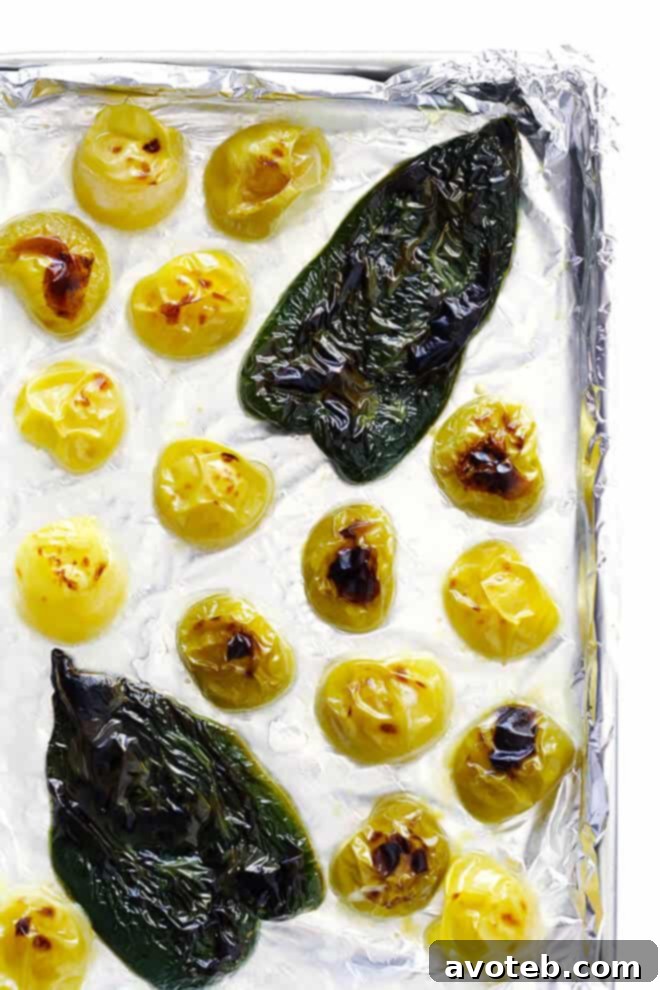 Fresh tomatillos and poblano peppers, charred under a broiler, essential for the vibrant green Pepián sauce.