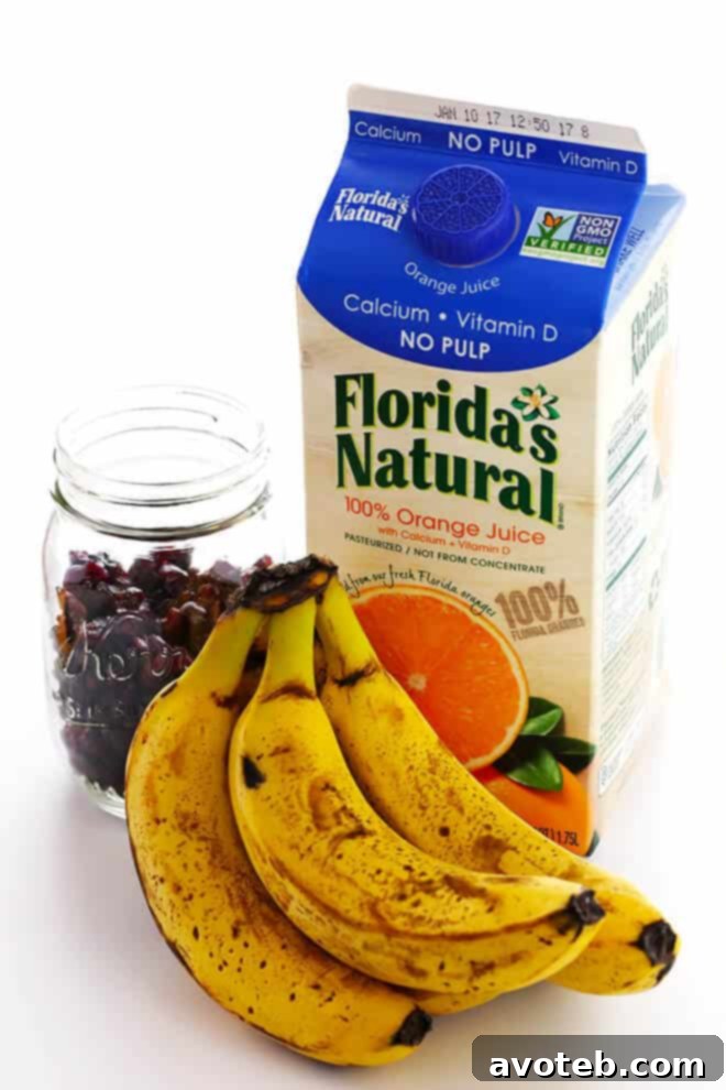 A selection of key ingredients for Cranberry Orange Banana Bread, including ripe bananas, dried cranberries, and Florida's Natural Orange Juice.