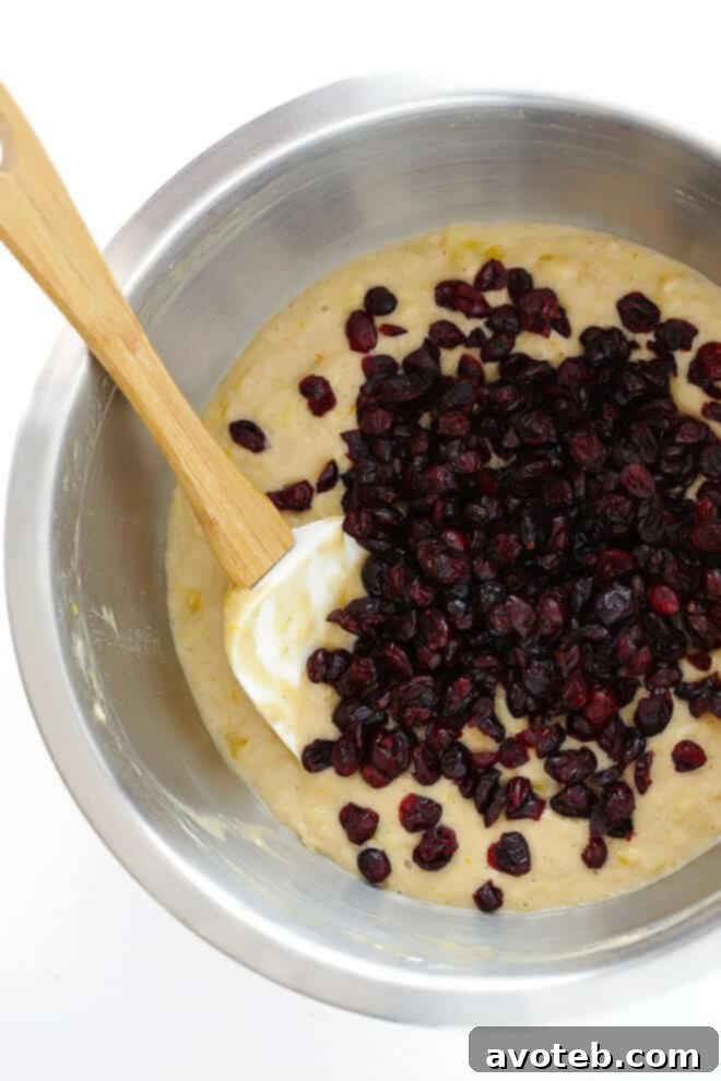 Mixing the wet and dry ingredients for Cranberry Orange Banana Bread batter.