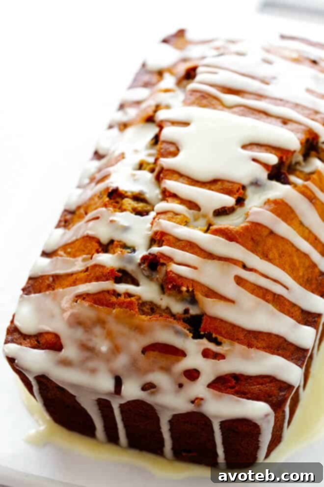 A close-up of a slice of Cranberry Orange Banana Bread with its delicious orange glaze.
