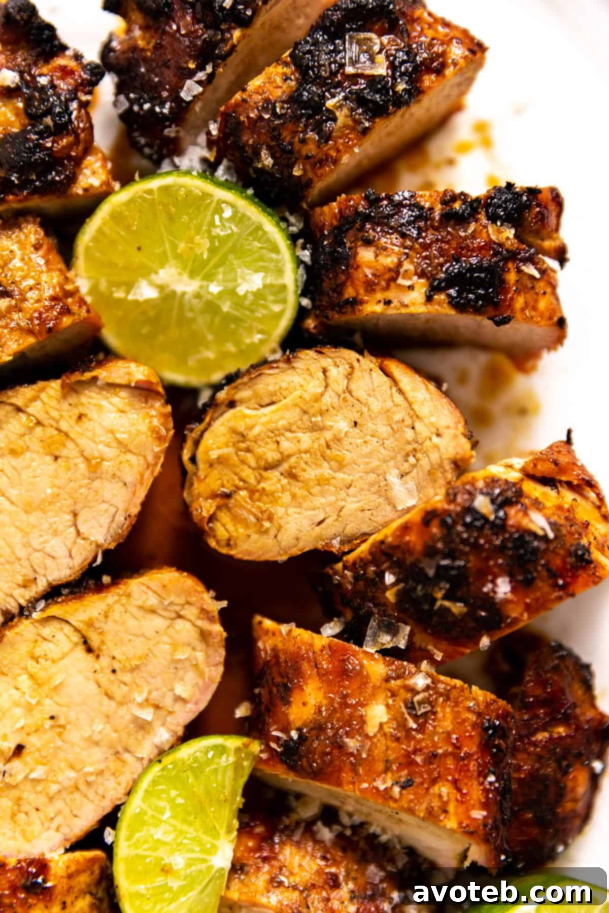 Sliced Ginger Lime Pork Tenderloin on a serving platter with garnishes