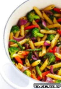 A vibrant bowl of Balsamic Veggie Pasta, garnished with Parmesan and fresh parsley, showcased on a light background. This appealing dish is packed with sautéed vegetables.