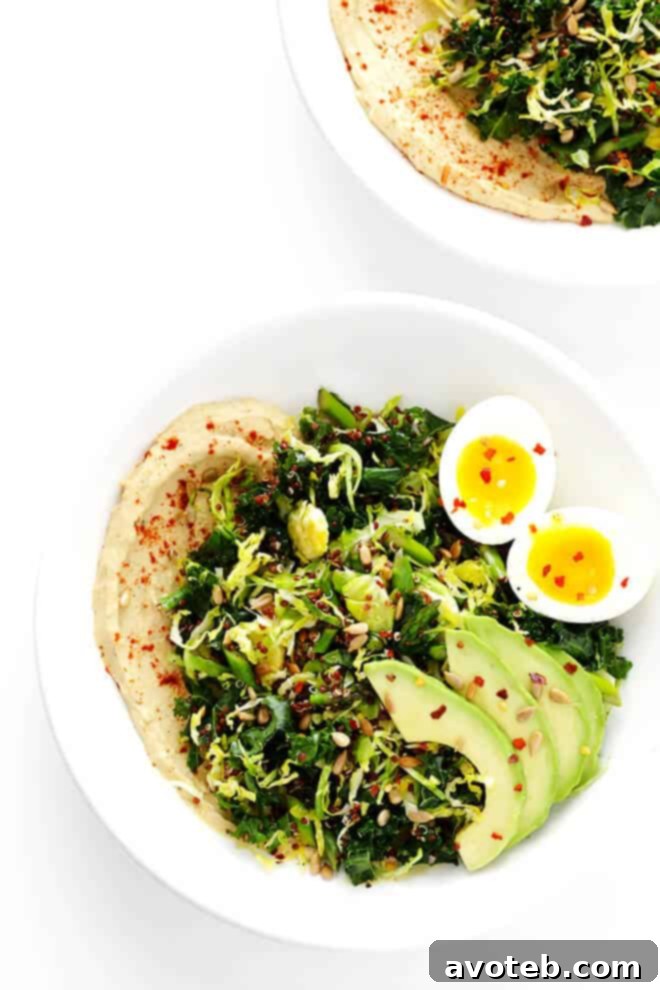The finished Hummus and Veggies Breakfast Bowl, beautifully presented and ready to enjoy, topped with an egg and seeds.