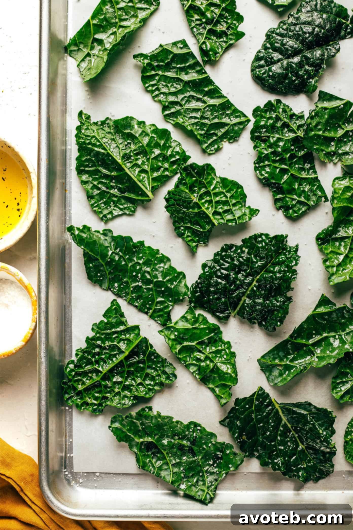 The simple ingredients for kale chips: fresh kale, a bottle of olive oil, and a small dish of sea salt.
