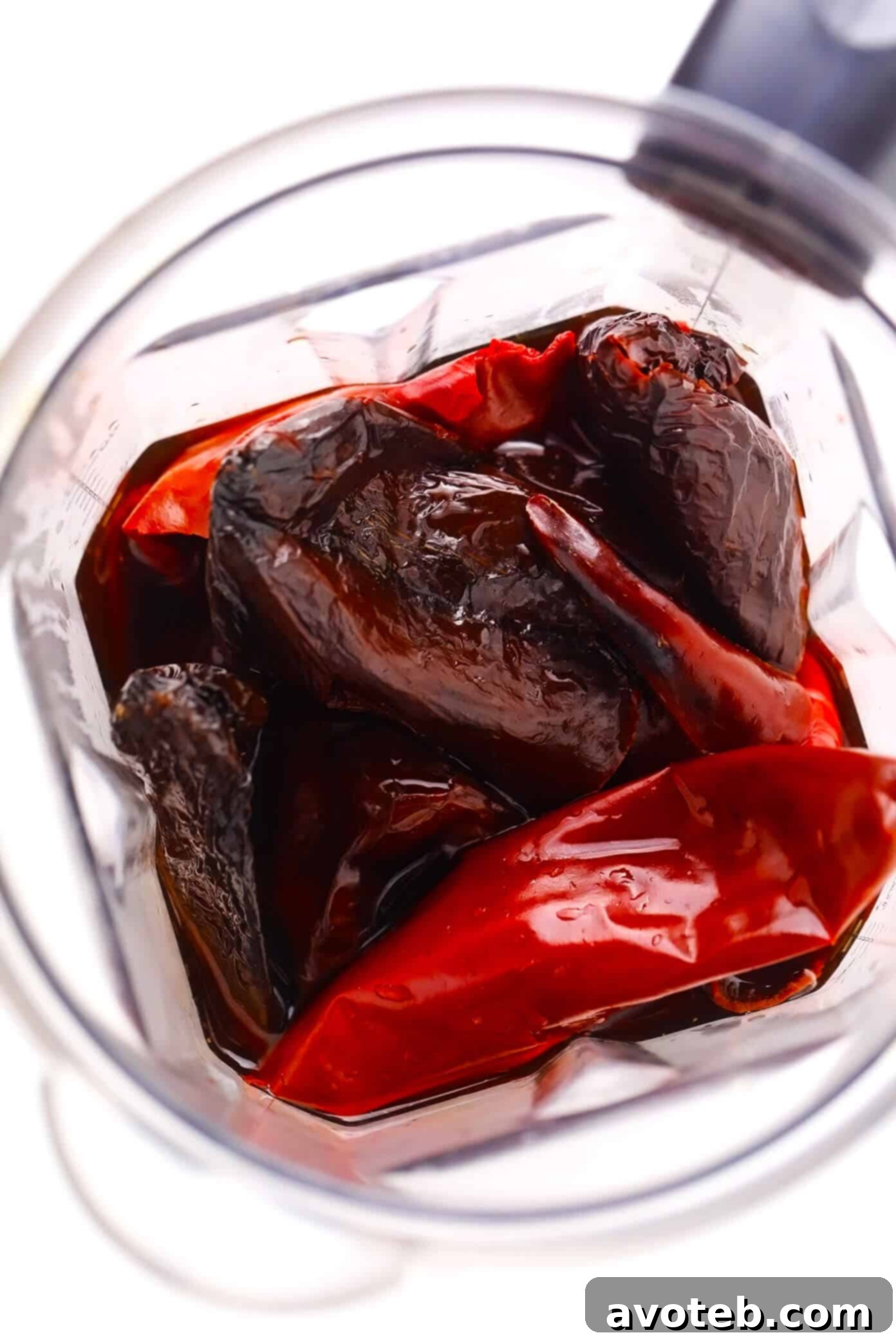 Preparing Chile Sauce for Pozole Dried red chiles soaking in hot water, then being transferred to a blender with some soaking liquid to create a smooth, vibrant chile sauce for Pozole Rojo.