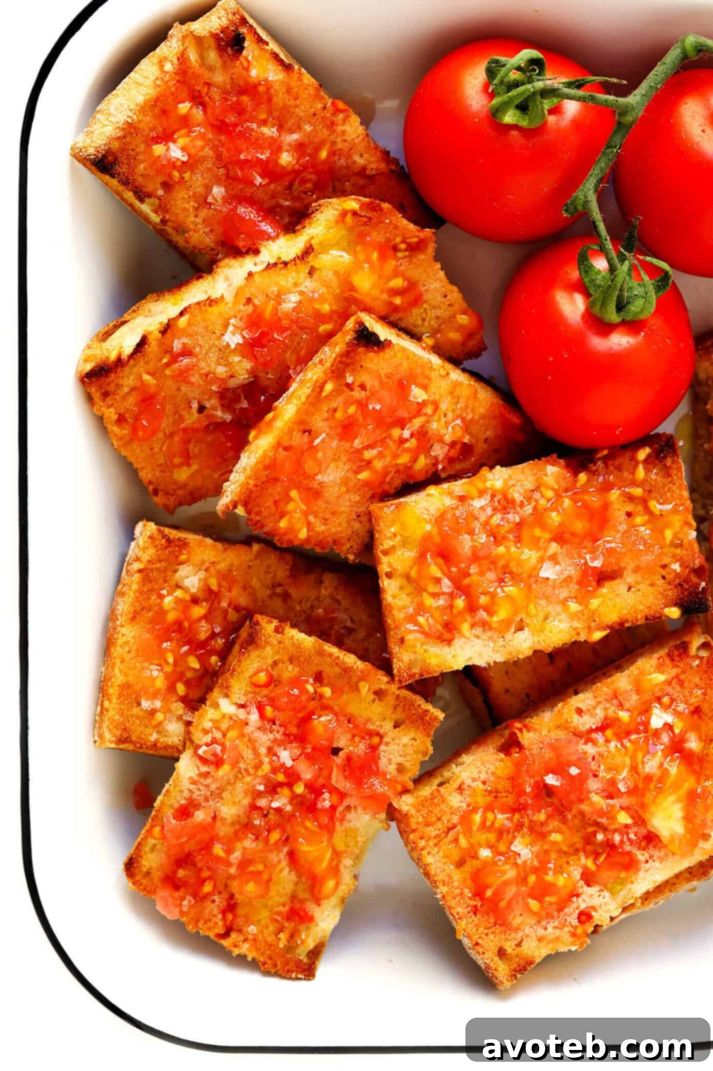 This Catalan Tomato Bread recipe is easy to make with just 5 ingredients, it's a great easy appetizer, side dish, or tapas recipe, and always tastes so fresh and delicious! | gimmesomeoven.com #tapas #spain #spanish #catalan #appetizer #bread #vegetarian #vegan Close-up of freshly prepared Pa Amb Tomàquet, garnished with olive oil and sea salt.