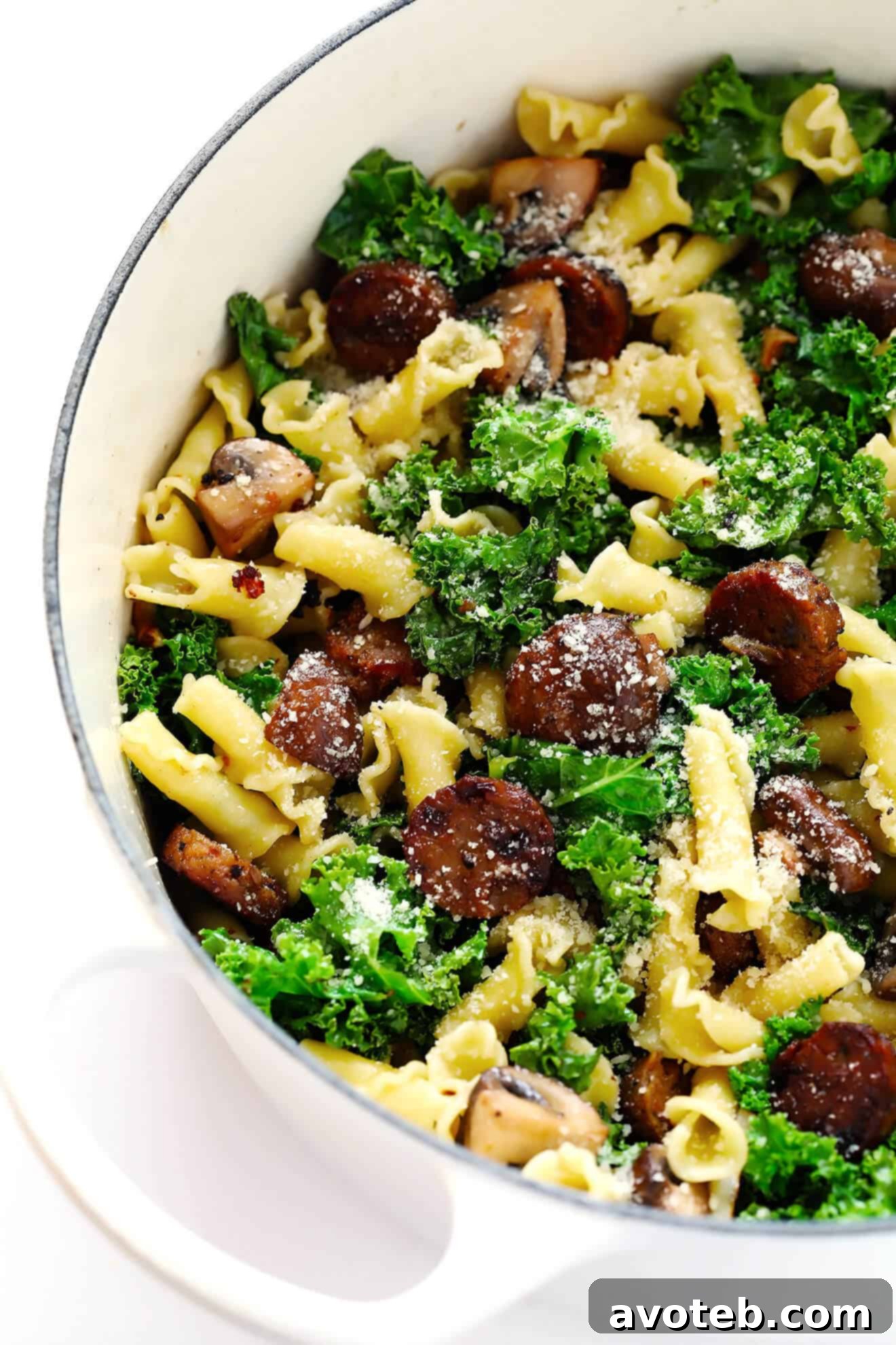 A stunning shot of a large pot filled with freshly made Pasta with Italian Sausage, Mushrooms, and Kale, ready to be enjoyed.