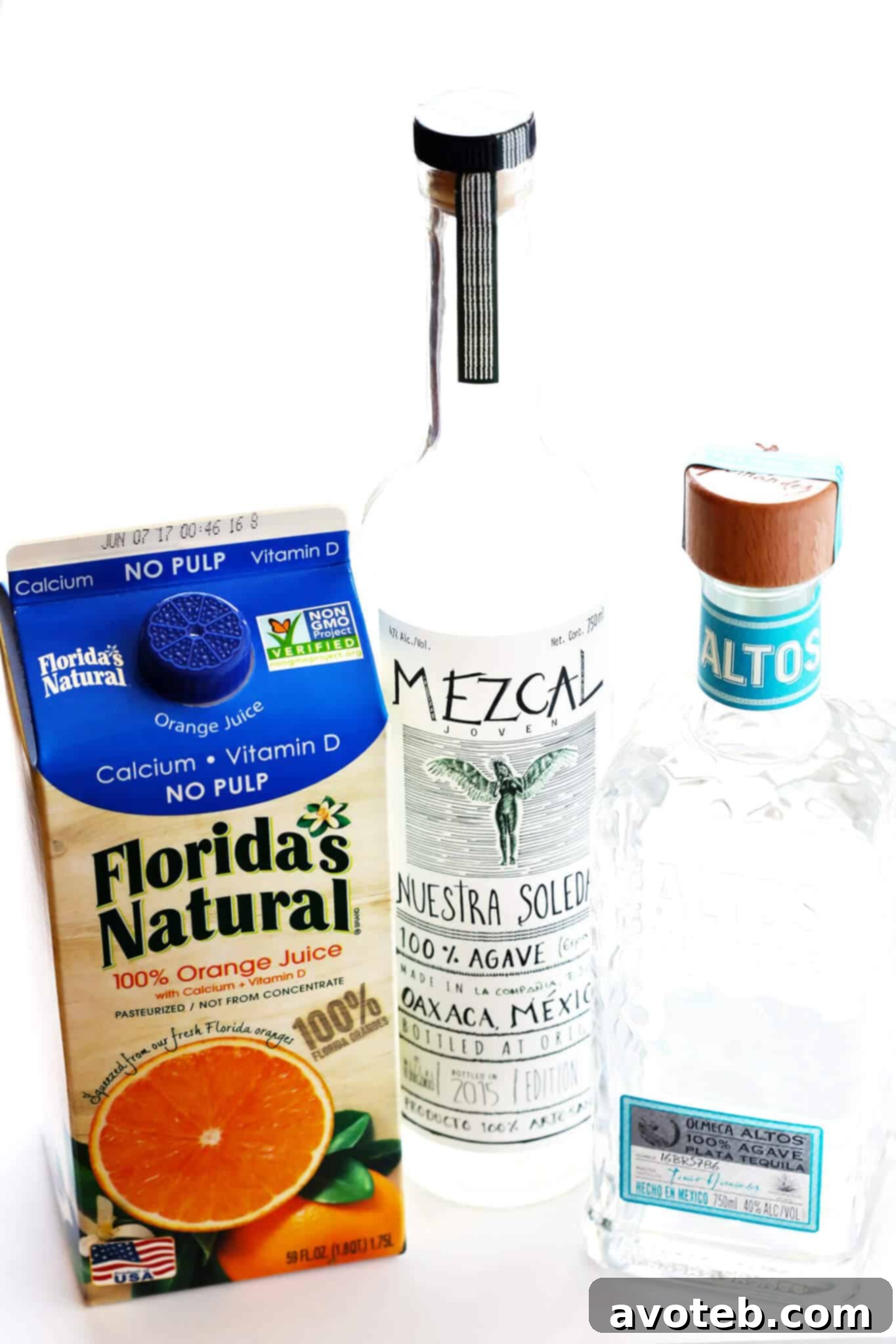 Agave Sunrise Mimosa 3 Ingredients laid out for a Tequila Sunrise Mimosa, including Florida's Natural orange juice, tequila, champagne, grenadine, and limes.