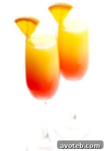 A vibrant Tequila Sunrise Mimosa cocktail in a champagne flute, garnished with an orange slice, perfect for brunch celebrations.