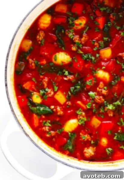 Italian Sausage Gnocchi and Tomato Soup served in a bowl with crusty bread.