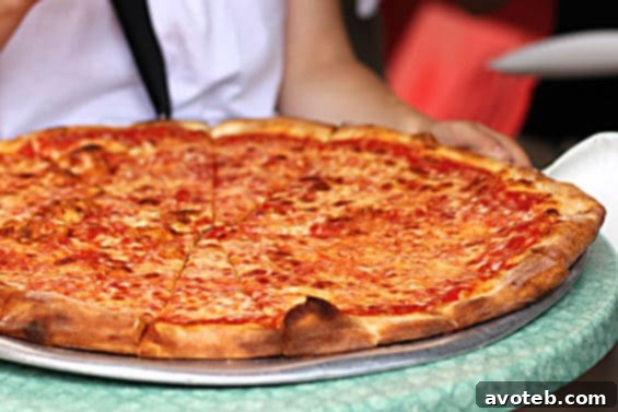 Sampling Joe's Pizza on a food tour Enjoying a huge slice of thin-crust pizza in New York City