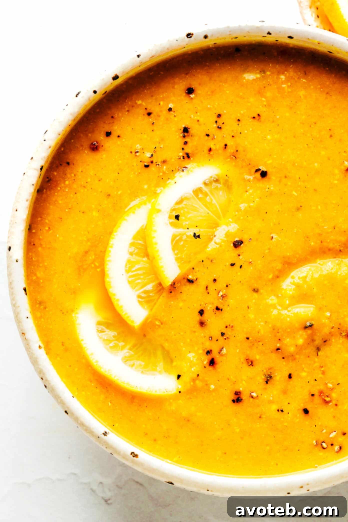 Closeup of a bowl of Lemony Lentil Soup, highlighting its creamy texture and vibrant color.