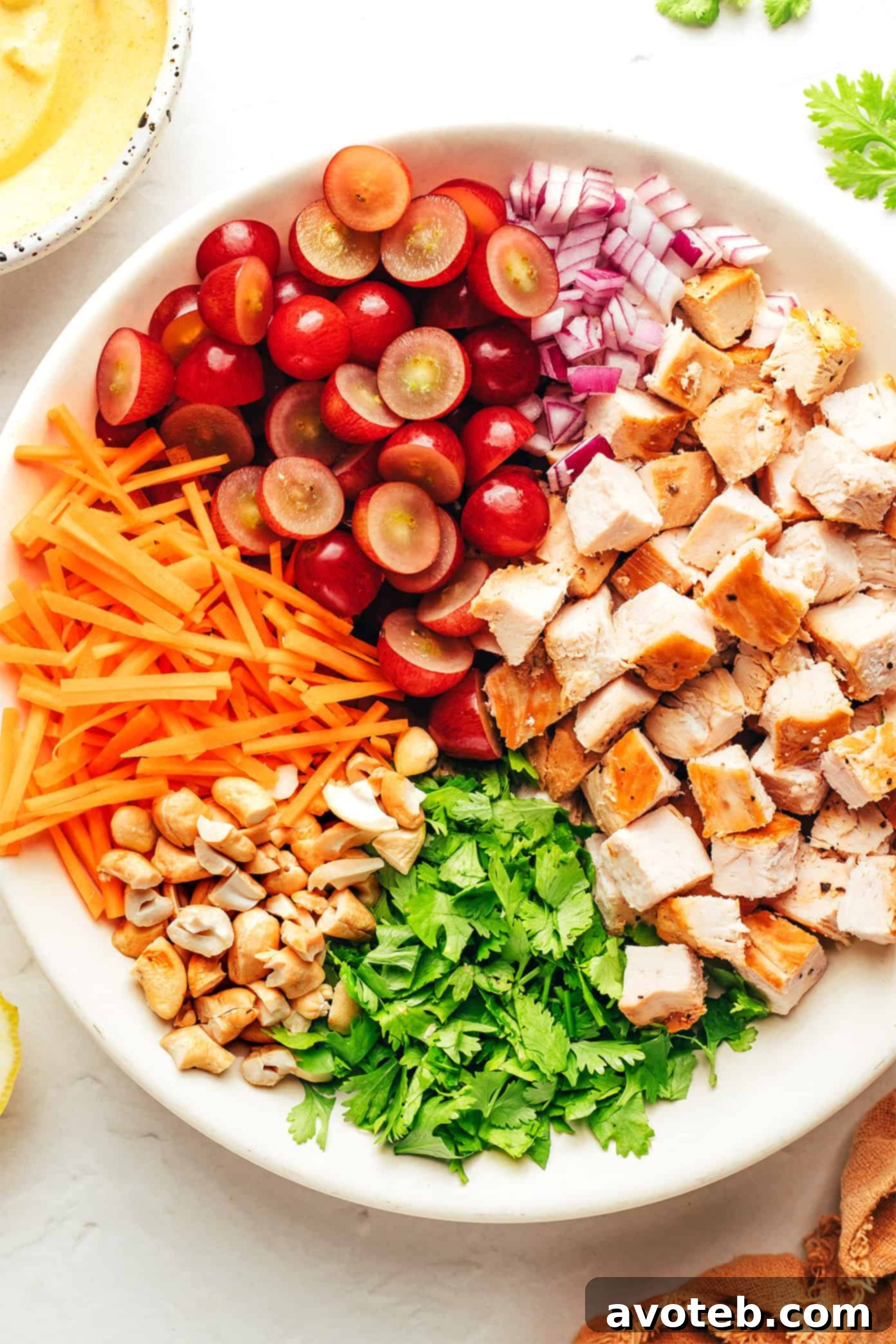 Curry chicken salad ingredients mixed together in a large serving bowl.