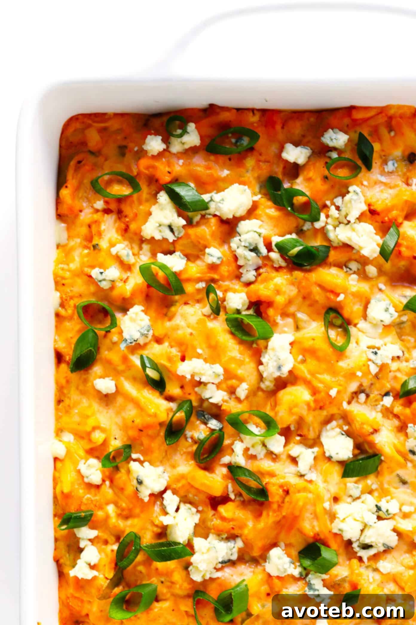 Serving the hot Buffalo Cauliflower Dip with fresh toppings like green onions and blue cheese.
