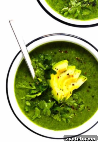 Green Goddess Soup in a white bowl with avocado and cilantro garnish
