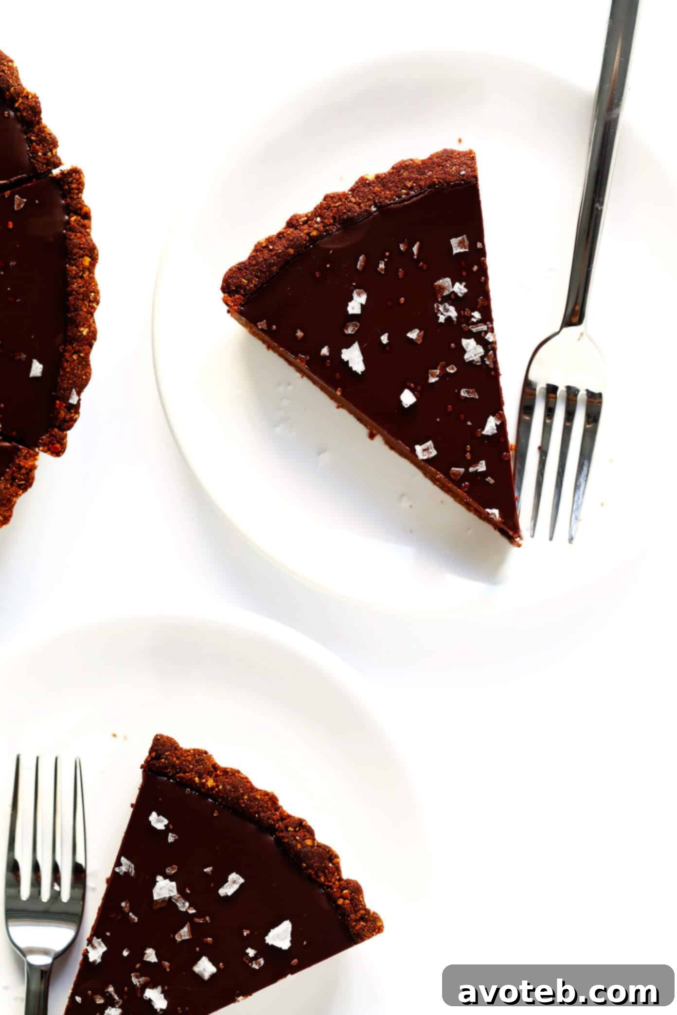 Close-up of a Gluten-Free Chocolate Tart, generously sprinkled with glittering flaky sea salt, highlighting the texture.