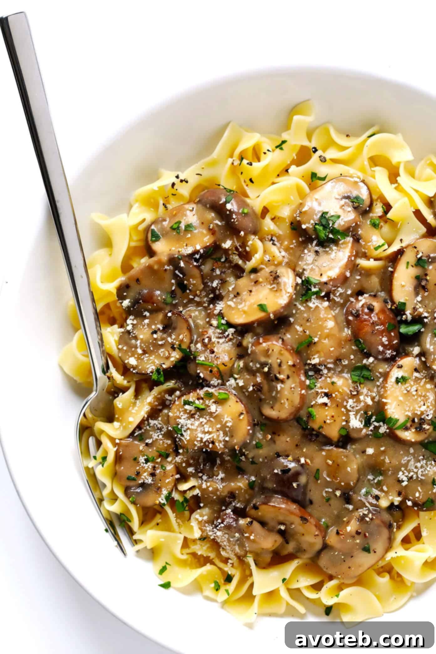 Step-by-step image showing how to combine sauce and noodles for Mushroom Stroganoff.