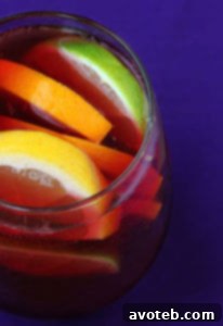 Red Sangria in a pitcher with glasses and fresh fruit