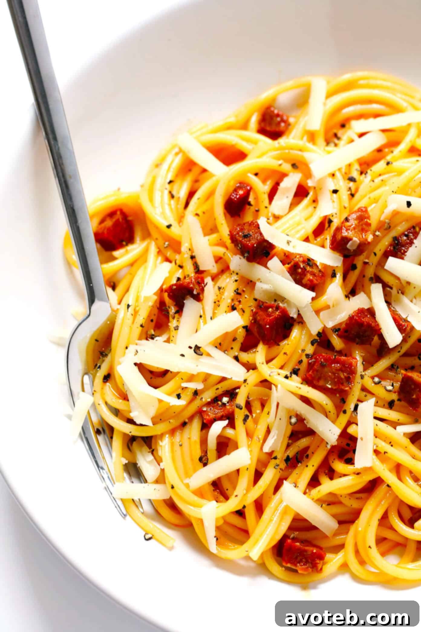 Spanish Chorizo Spaghetti Carbonara topped with Manchego cheese and black pepper. A close-up of Spanish Chorizo Spaghetti Carbonara, richly garnished with grated Manchego cheese and black pepper.