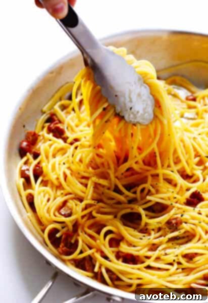 A top-down view of a serving of Spanish Chorizo Spaghetti Carbonara, highlighting the pasta, chorizo, and cheese.