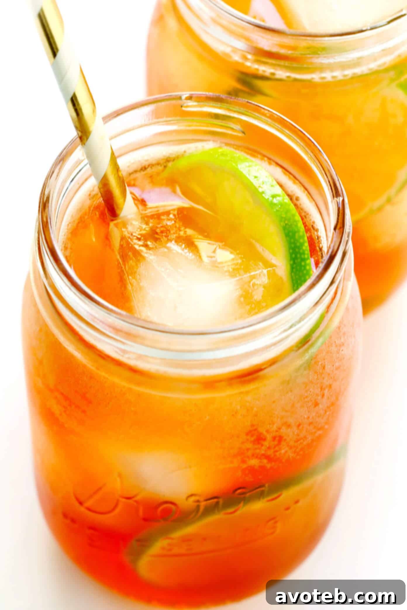 Hand stirring a Horsefeather Cocktail in a highball glass with ice, whiskey, ginger beer, and bitters.