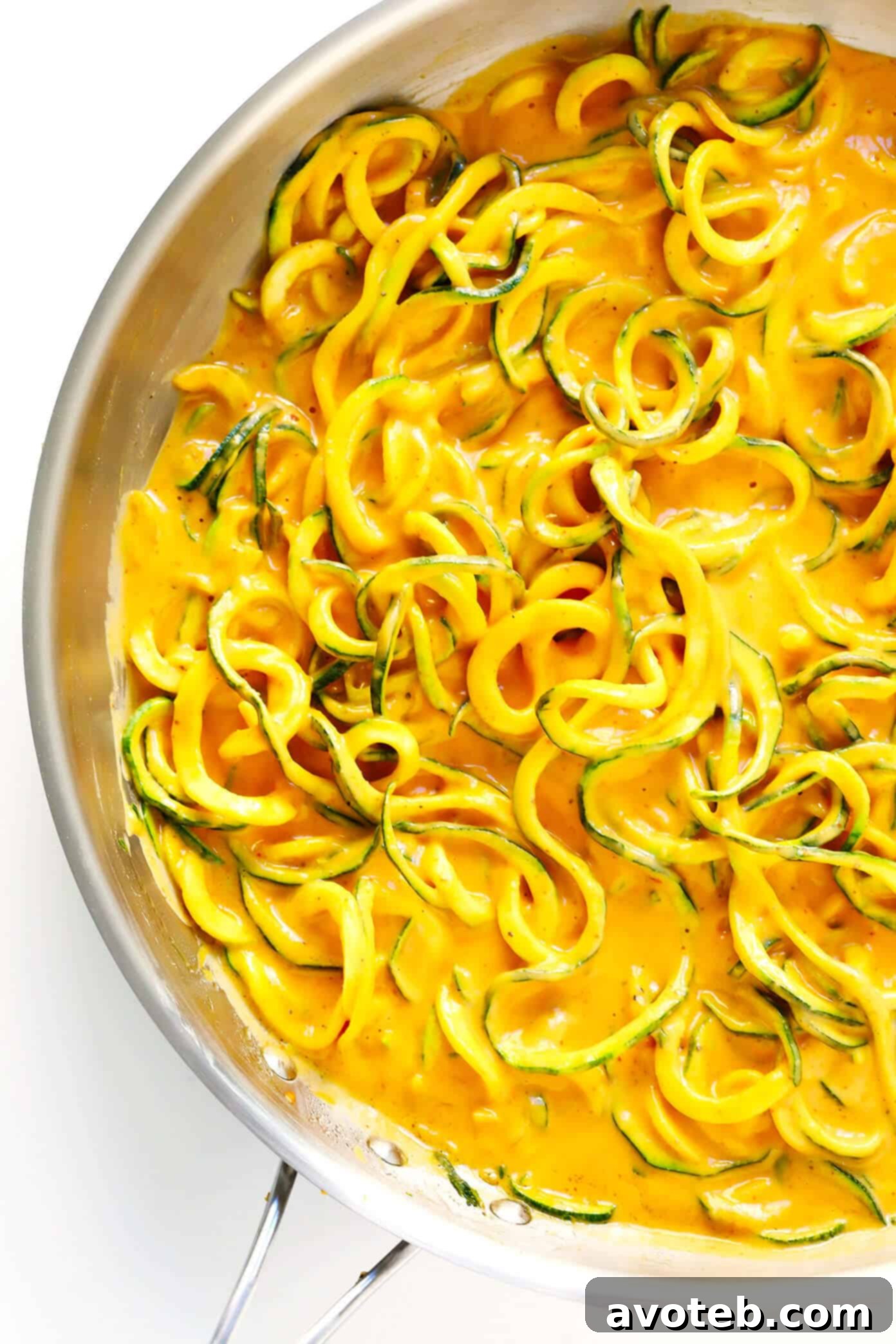 Zucchini noodles tossed with the creamy red curry sauce in a pan