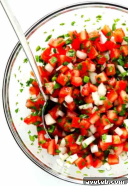 Pico de Gallo in a white bowl with tortilla chips.