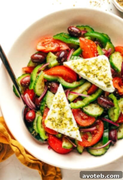 Authentic Greek Salad with feta on top, in a white bowl