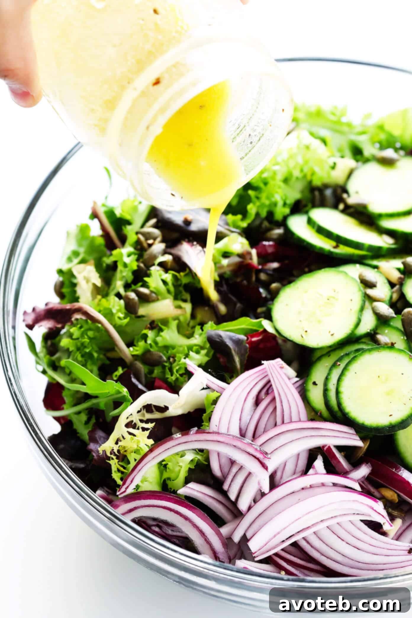 Adding Everyday Salad Dressing to a bowl of fresh salad ingredients.