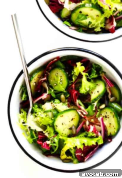 A delicious Everyday Salad with fresh greens, cucumber, red onion, and pepitas.