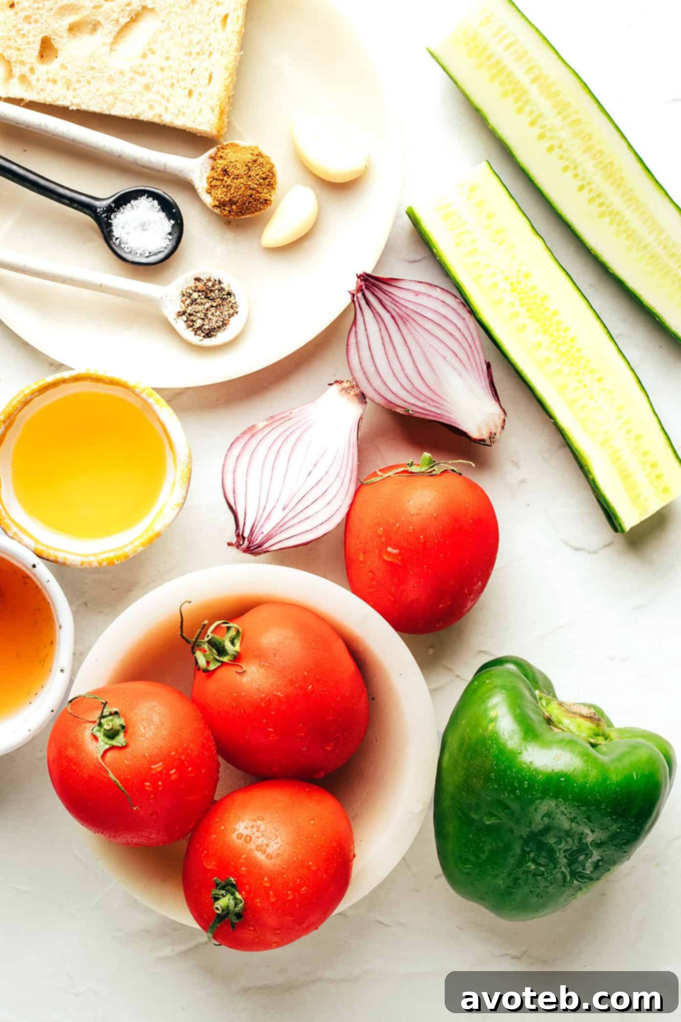 The Original Gazpacho 3 Close-up of fresh, ripe tomatoes, cucumbers, green bell peppers, and garlic cloves, essential ingredients for an authentic Spanish gazpacho.