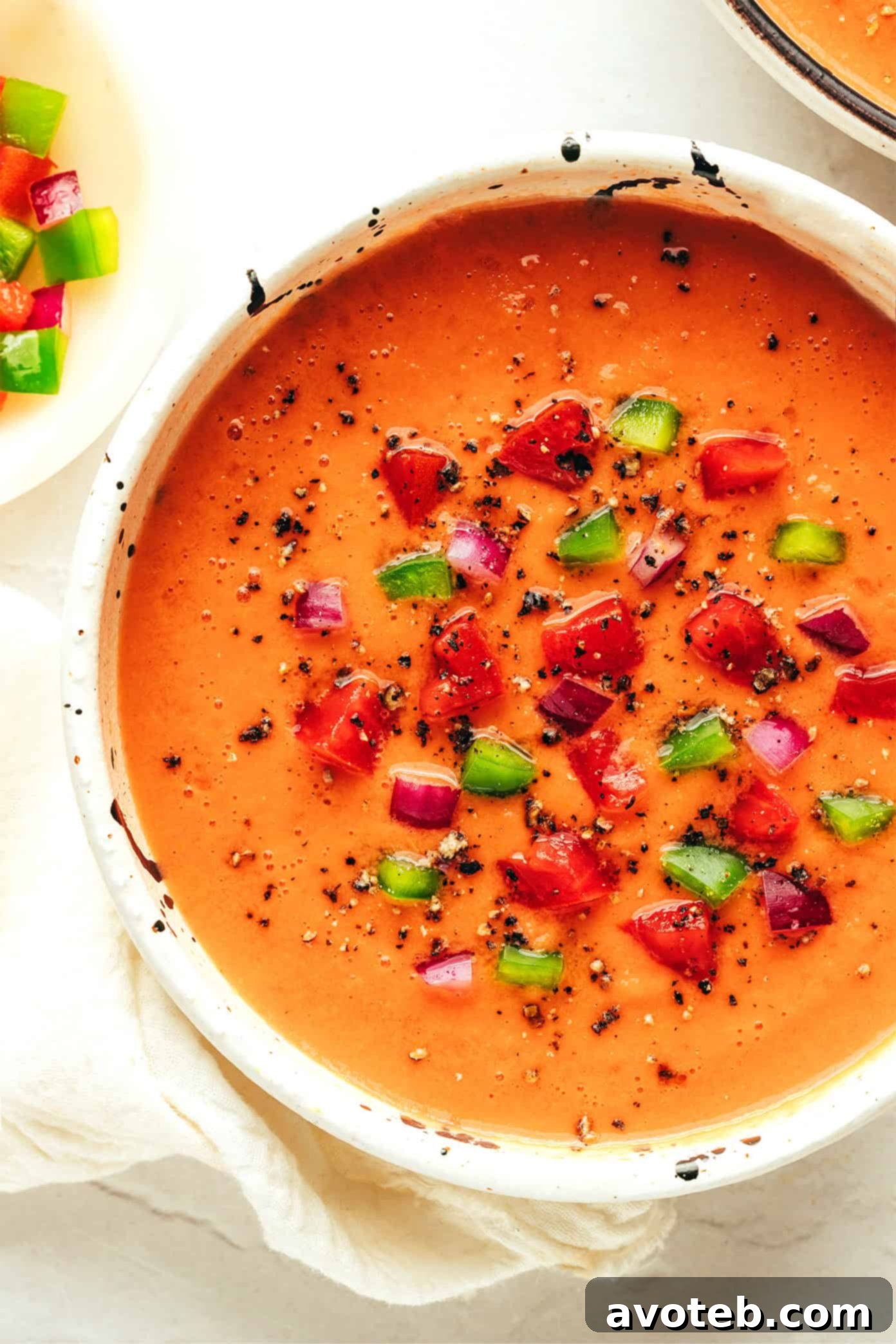 The Original Gazpacho 5 A beautifully garnished bowl of gazpacho, topped with fresh herbs, a swirl of olive oil, and croutons, ready to be enjoyed.