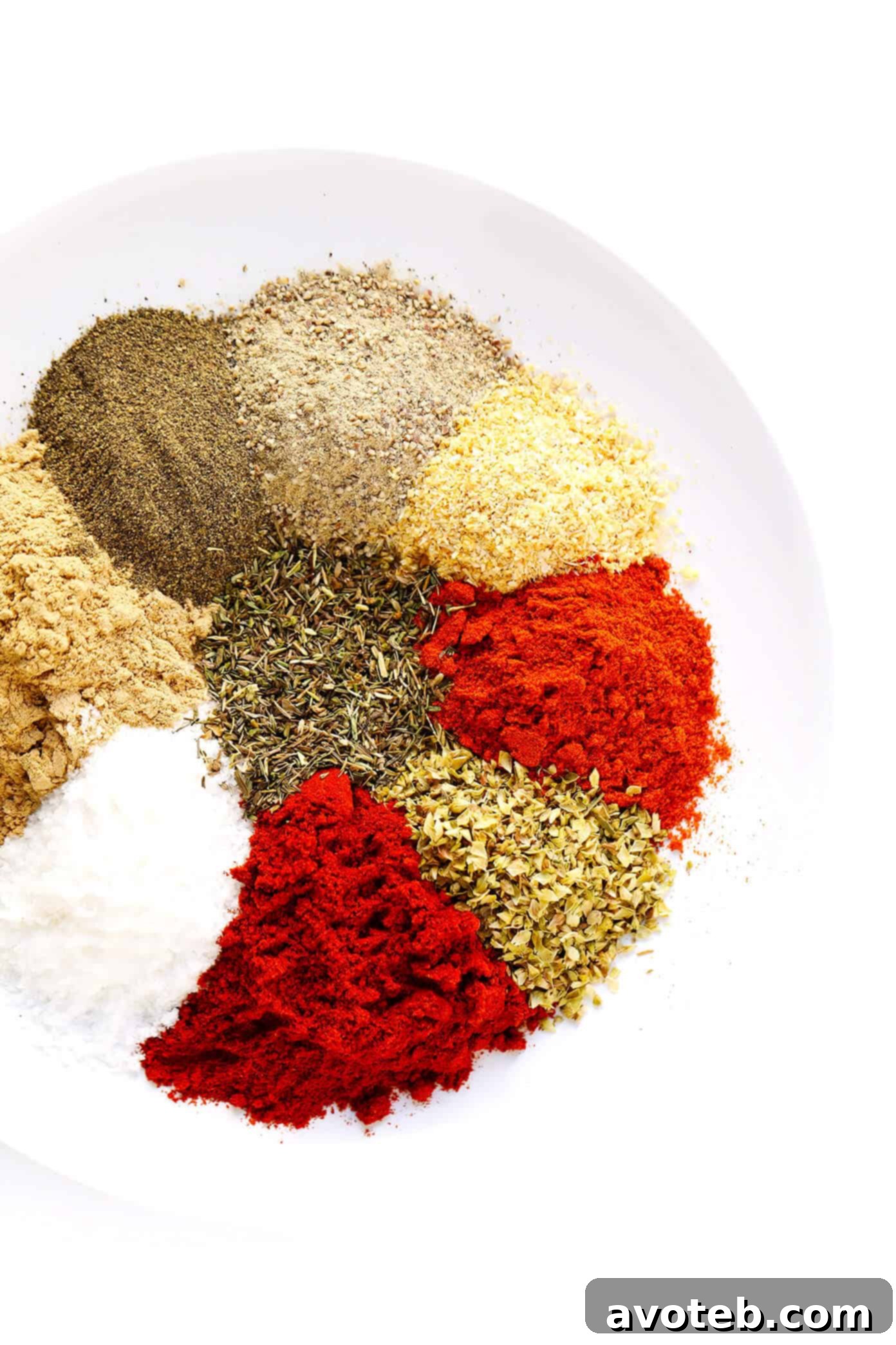 Various individual spices are neatly arranged in small bowls, showcasing the ingredients that make up the Cajun seasoning blend.