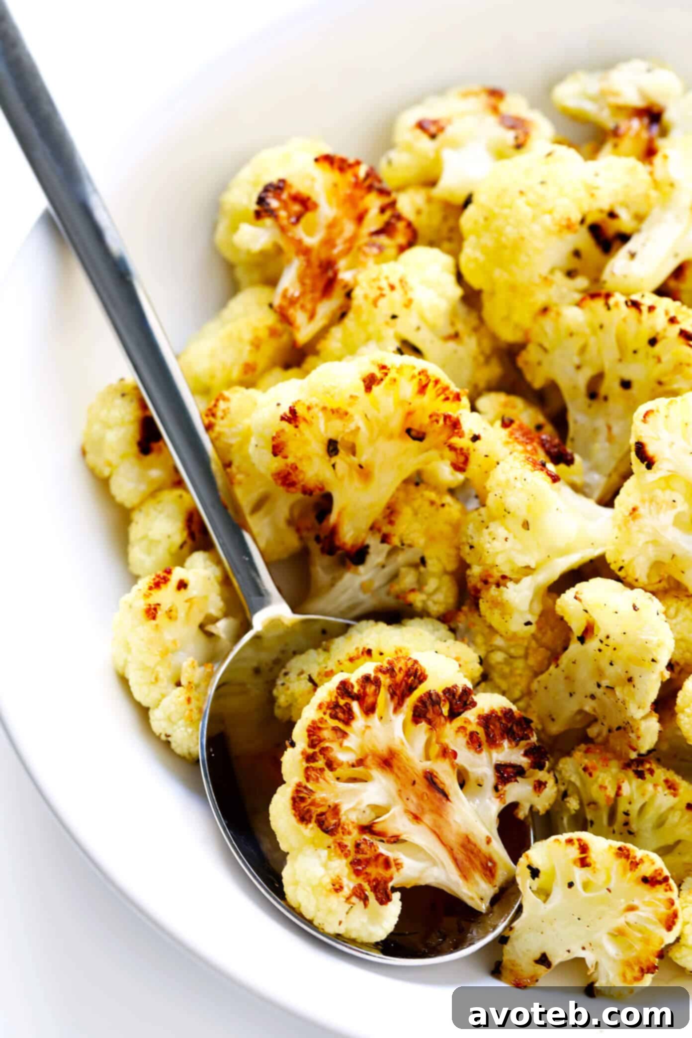 The BEST Roasted Cauliflower recipe -- super easy to make in the oven, naturally #glutenfree and #vegan, and easy to customize with any of your favorite seasonings. It's the perfect healthy side dish. Or perfect for adding to a salad, soup, pizza, dip, pasta, tacos or more! | Gimme Some Oven How To Make Roasted Cauliflower - A close-up of golden brown florets