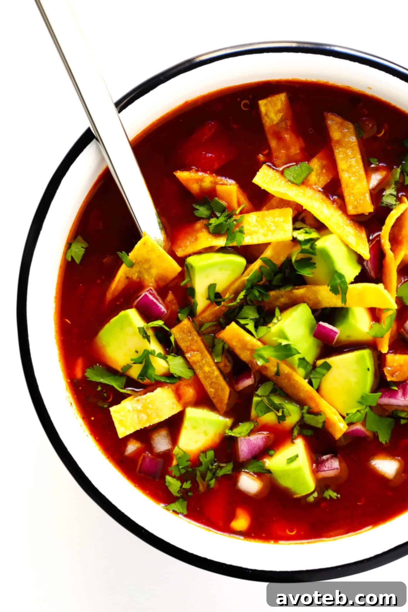 Vegetarian Quinoa Tortilla Soup: A hearty, flavorful, and naturally vegan and gluten-free Mexican soup. Made with a delicious chile tomato broth, quinoa, and topped with avocado for a comforting and healthy dinner.
