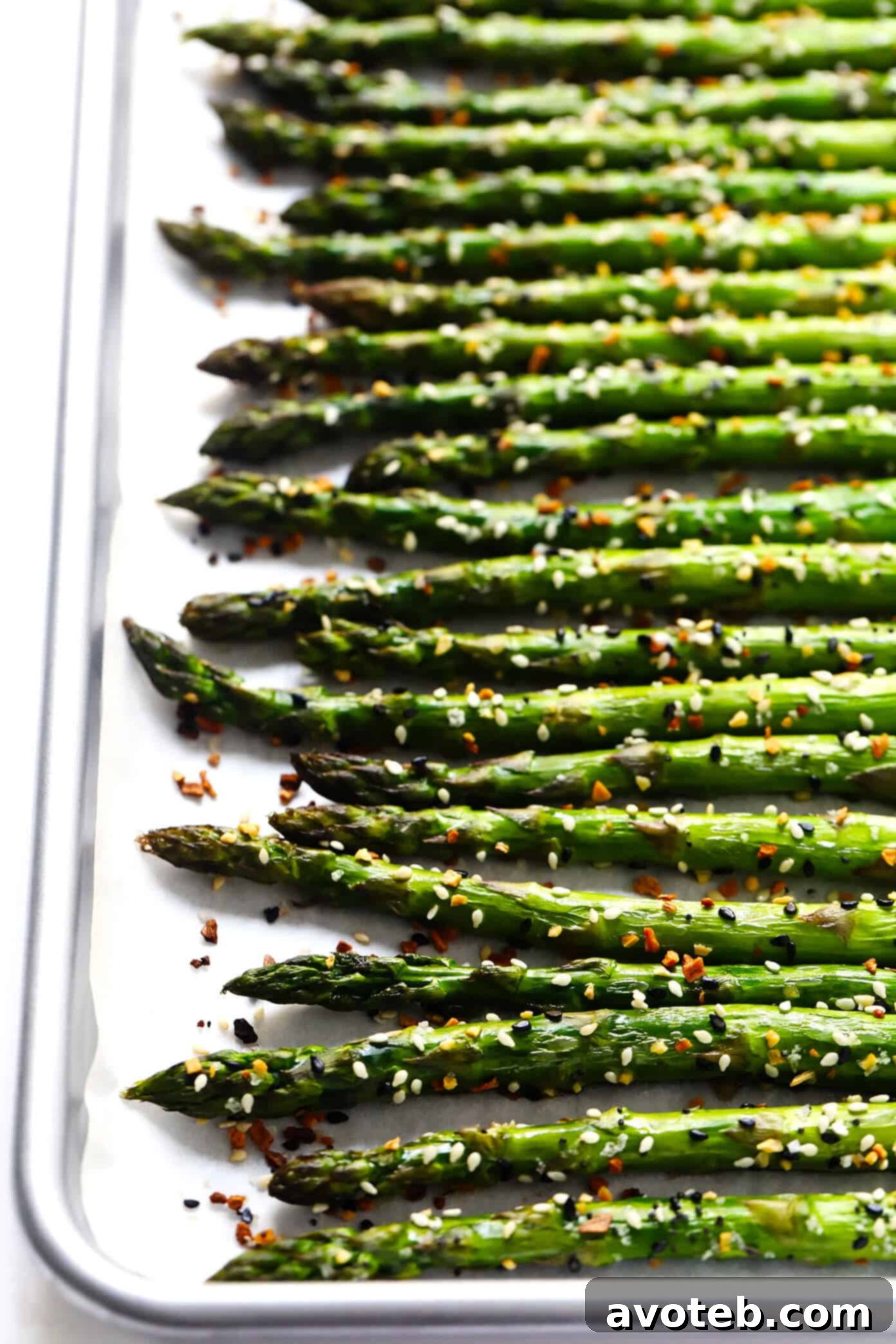 Kick your roasted asparagus recipe up a notch this season with some everything bagel seasoning! It's super quick and easy to make, naturally vegan and gluten-free, and makes the most delicious healthy side dish. | Gimme Some Oven #asparagus #side #vegetable #healthy #dinner #thanksgiving #christmas #holiday #fall #winter "Everything" Roasted Asparagus - a close-up shot of seasoned asparagus spears ready for roasting.