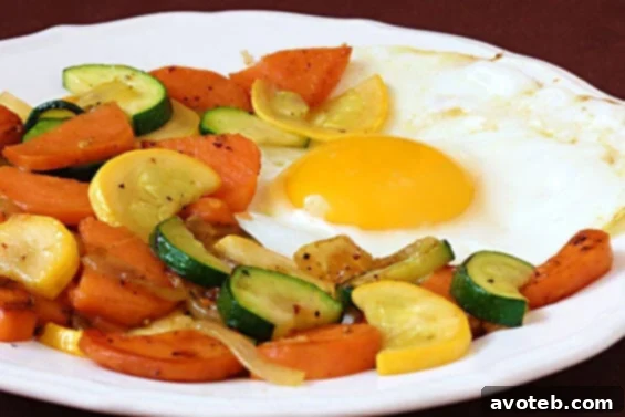 Plated Sweet Potato and Zucchini Hash topped with a sunny-side-up egg