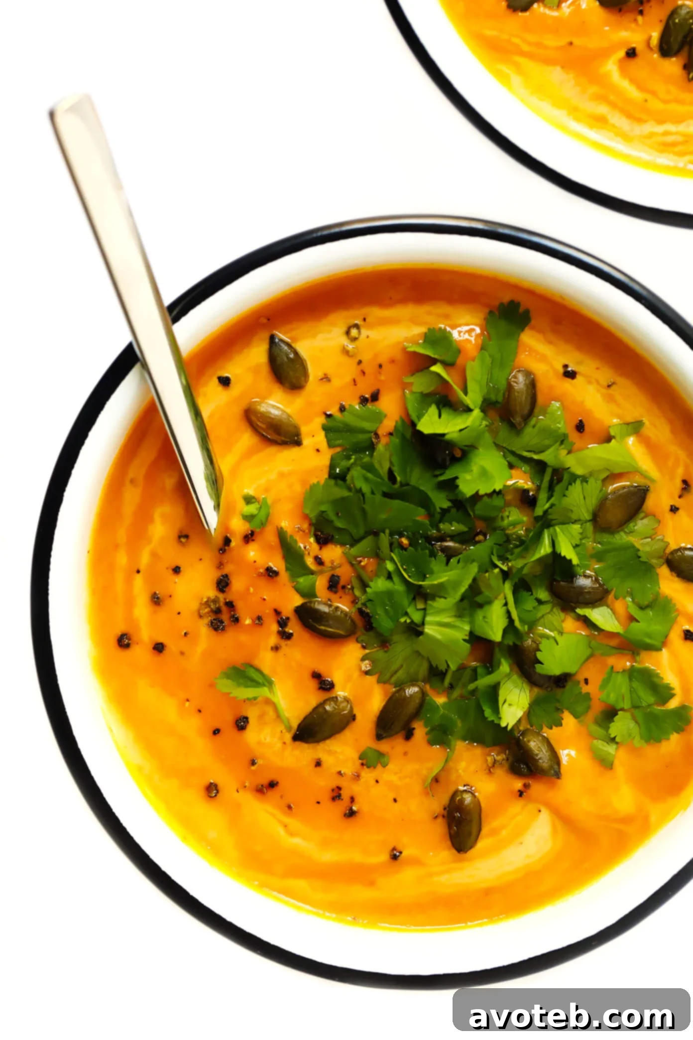 Rich and creamy Thai Curried Pumpkin Soup, garnished with fresh cilantro and pepitas. A perfect vegan and gluten-free fall recipe ready in 20 minutes.